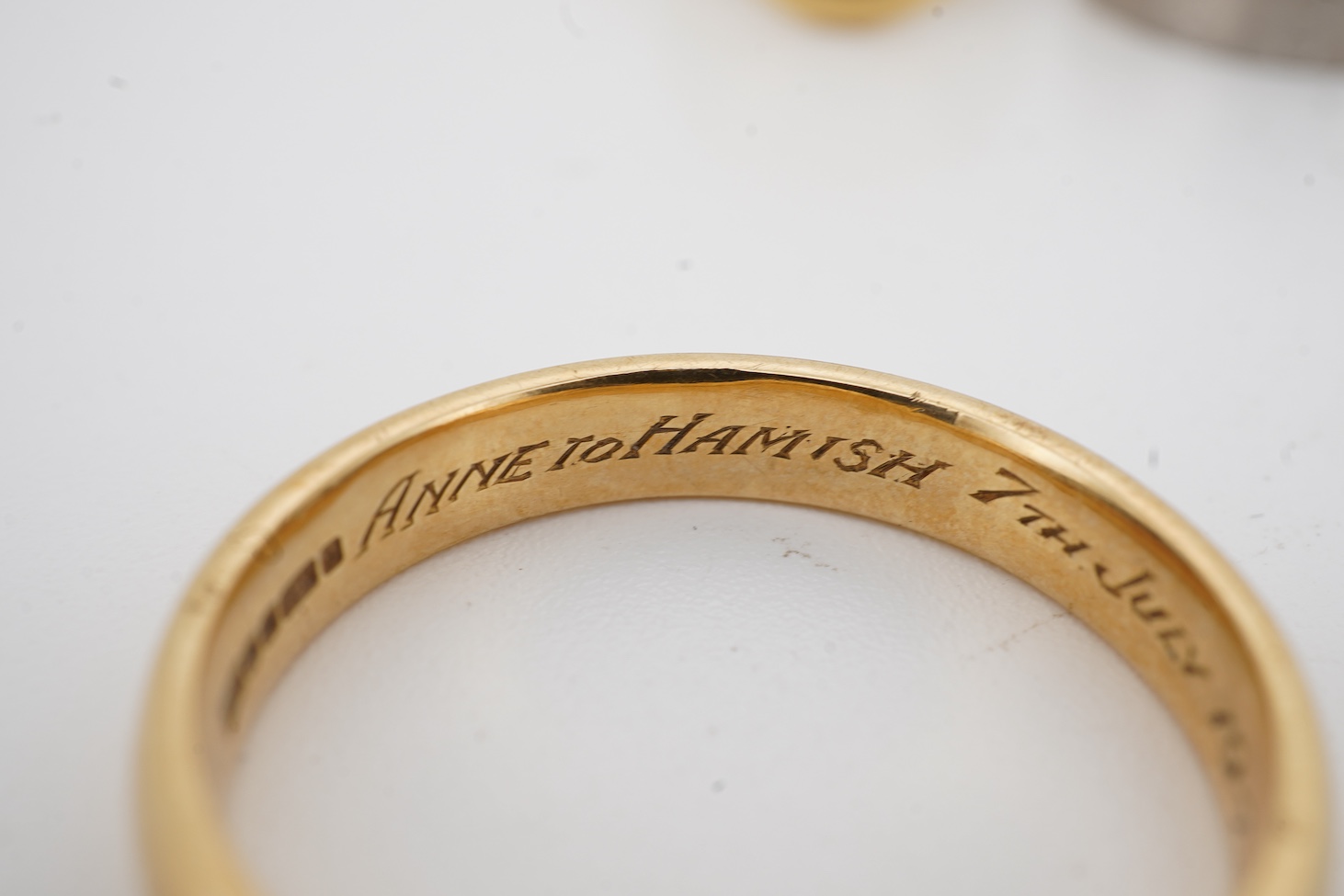 A 1990's 18ct gold wedding band, with engraved inscription, size U/V, a similar signet ring with engraved monogram and inscription, size I and an early 1970's 18ct white gold band, size O, gross weight 15.4 grams.